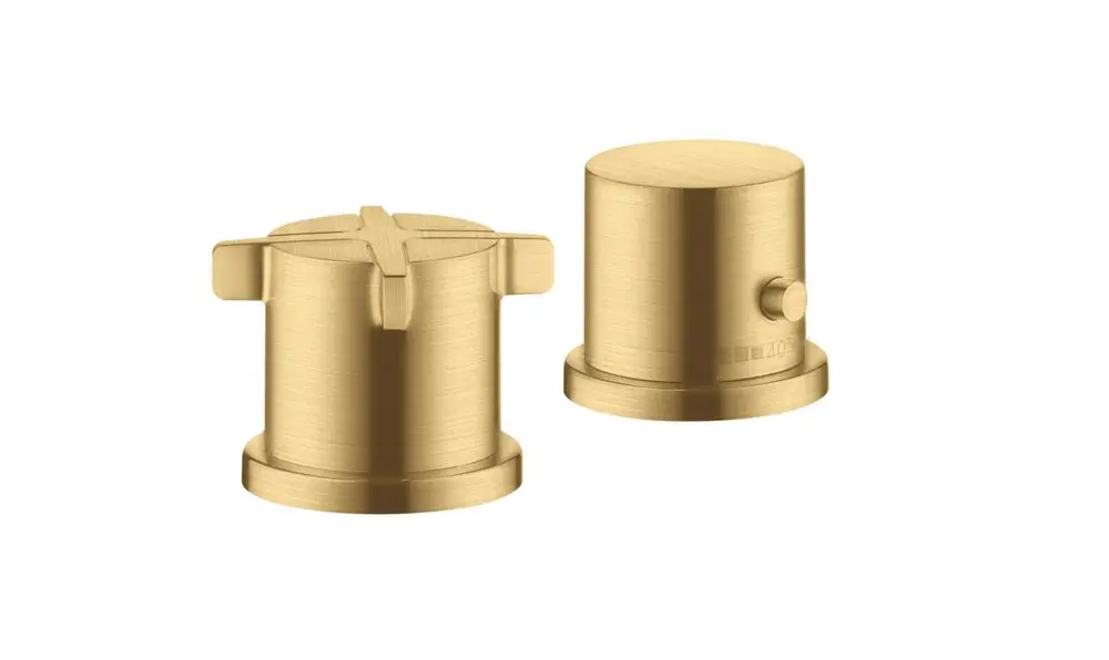 Zwei runde Bedienknöpfe in Brushed Gold Optic von AXOR, einer mit Kreuzform und der andere mit seitlichem Druckknopf, zum Einsatz in Wannenrandarmaturen.